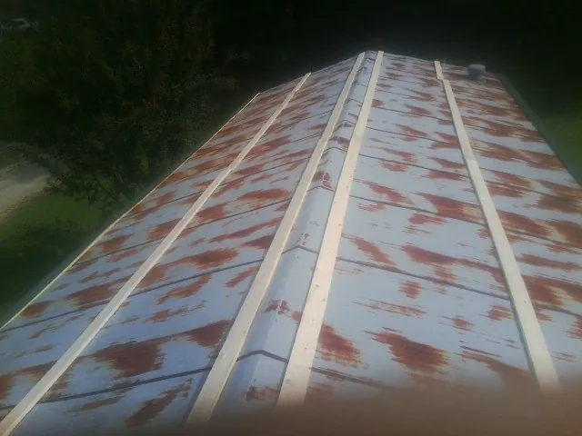 Rusted metal roof panels with new wood purlins before replacement — Storm Damage Roof Repair in Marshfield by Roofing Brothers